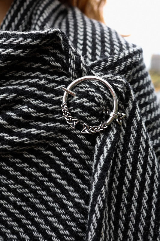 Woven Celtic shawl in black and white with silver Trinity knot brooch and fringe detail