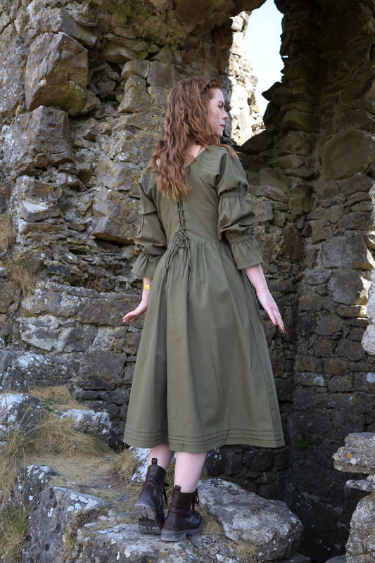 Fiadh sage green corset back midi dress showing the adjustable lace-up waist, gathered skirt and long sleeves