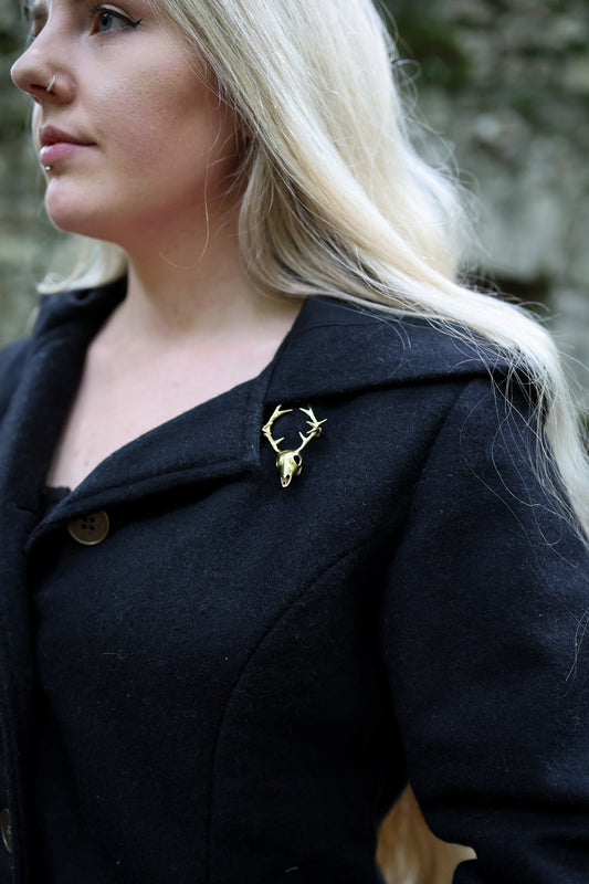 Brass stag pin brooch on black heavy felt wool coat
