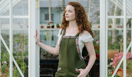 Adjustable Green Dungarees styled in a greenhouse doorway with wide leg fit and checked trim details
