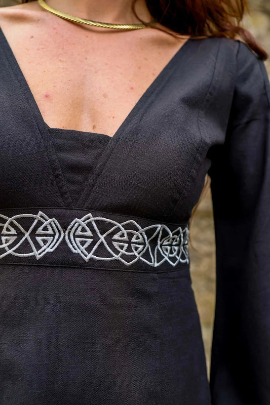 Close-up of Maeve Black Celtic Dress bodice with Celtic knot embroidery, empire waist and deep neckline detail