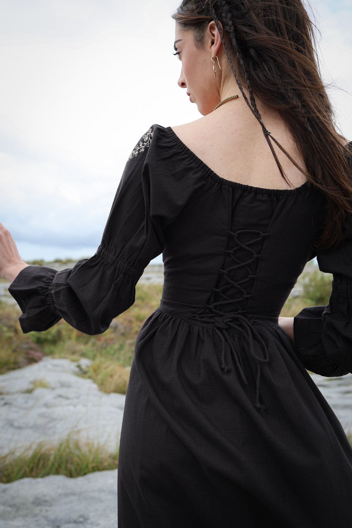 Black embroidered cotton dress showing the adjustable lace-up corset back and elasticated neckline.