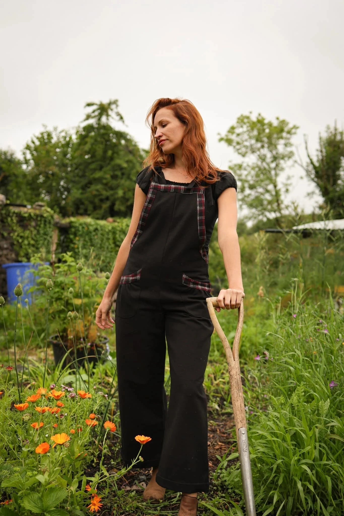 Black folklore fashion dungarees with checked tweed trim and front pockets styled in a wild garden setting designed by Celtic Fusion