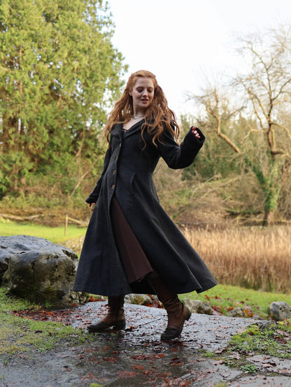 Black gothic style maxi wool coat in motion showing full flowing skirt, long sleeves and tailored waist