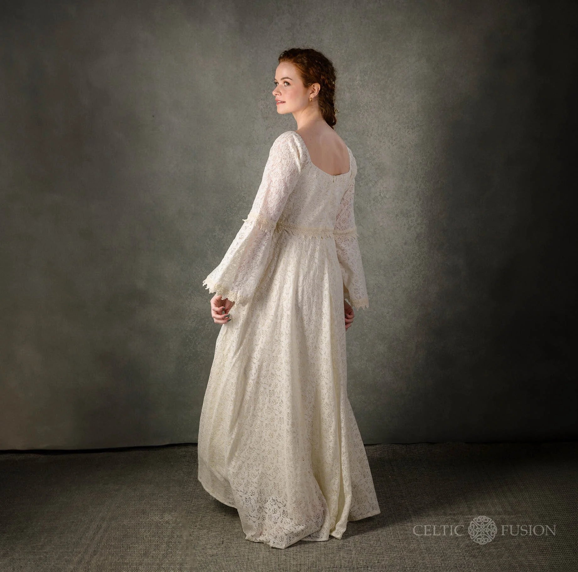 Side back studio view of the Bébhinn Boho Lace Wedding Dress, sustainable cotton lace gown with bell sleeves.