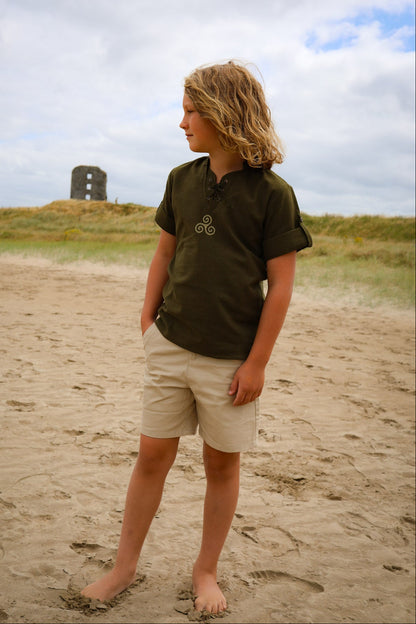 Green Triskele embroidered shirt for boys with lace-up neck and roll-up sleeves, part of Irish clothing for boys collection by Celtic Fusion Design.