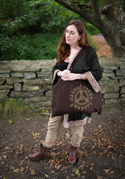Brigid Celtic tote bag worn over the shoulder, showing the printed knotwork design and practical everyday size.