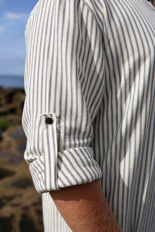 Casual cream and blue striped fisherman shirt with roll-up sleeve secured by a button tab in textured cotton fabric.