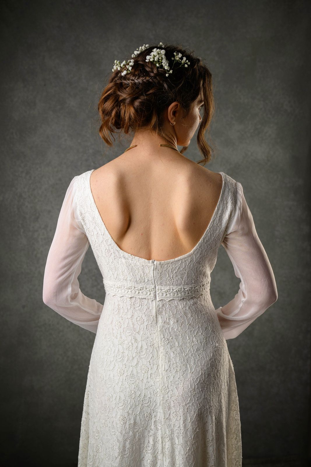 Close-up of Annagh Celtic bridal gown with sleeves showing low rounded back, lace bodice and sheer chiffon sleeves