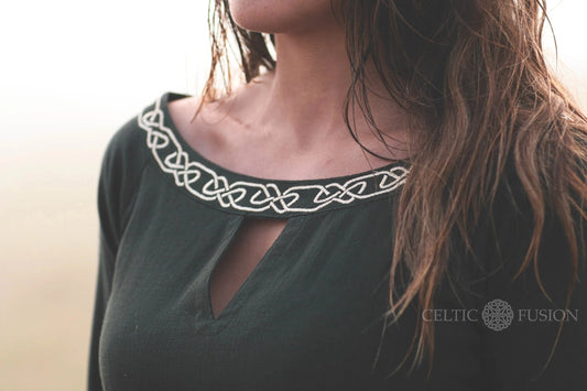 Close up of Celtic knot embroidery on the neckline of a green Celtic dress, showing the detail of this breathable long sleeve folklore dress.