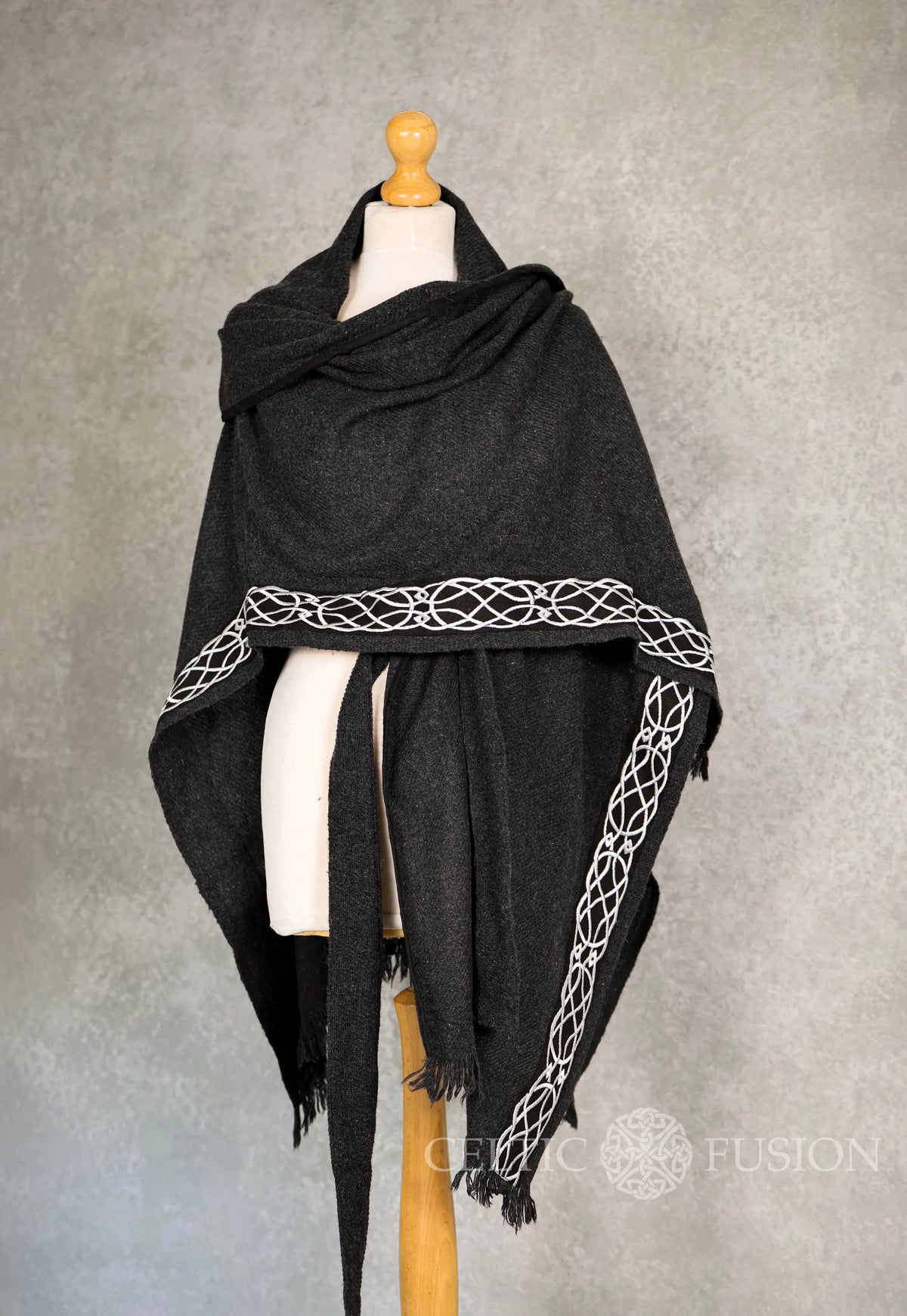 Black Celtic wool cape multi-style design wrapped across mannequin showing embroidered border and versatile layered styling