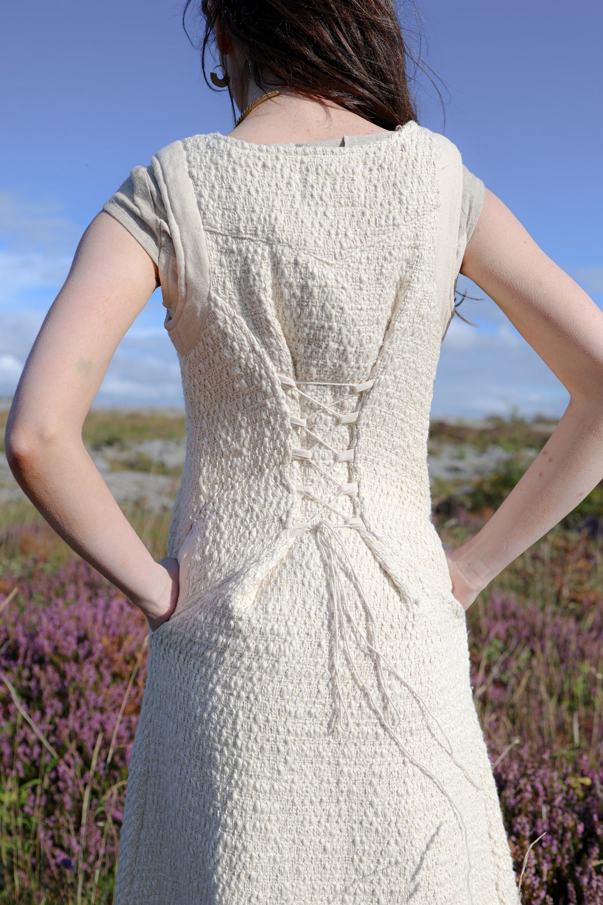 Cream folklore layering vest showing the adjustable lace-up corset back and fitted waist.