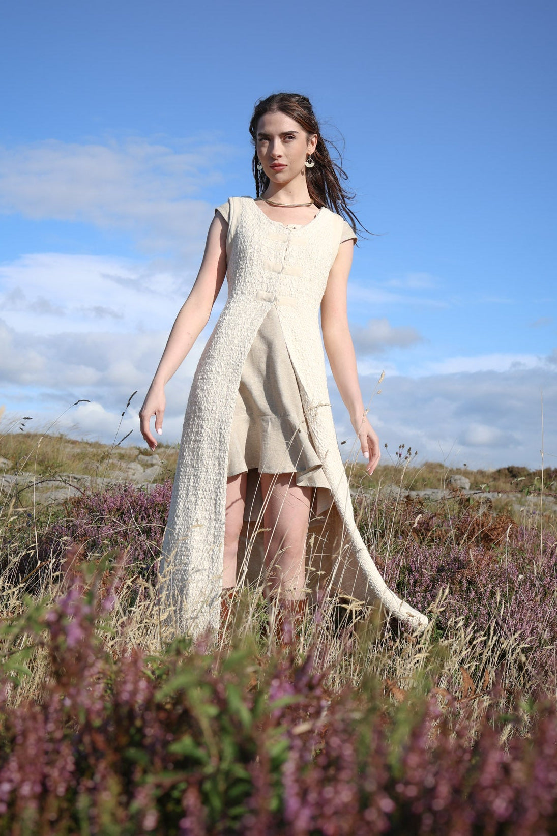Cream folklore overdress layered over a dress, creating a long romantic silhouette with an open front.