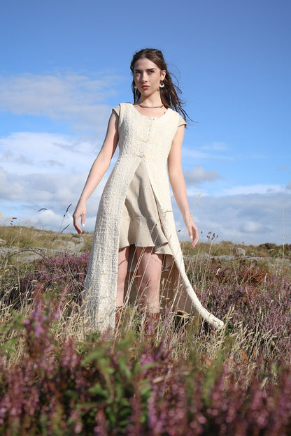 Cream folklore overdress layered over a dress, creating a long romantic silhouette with an open front.