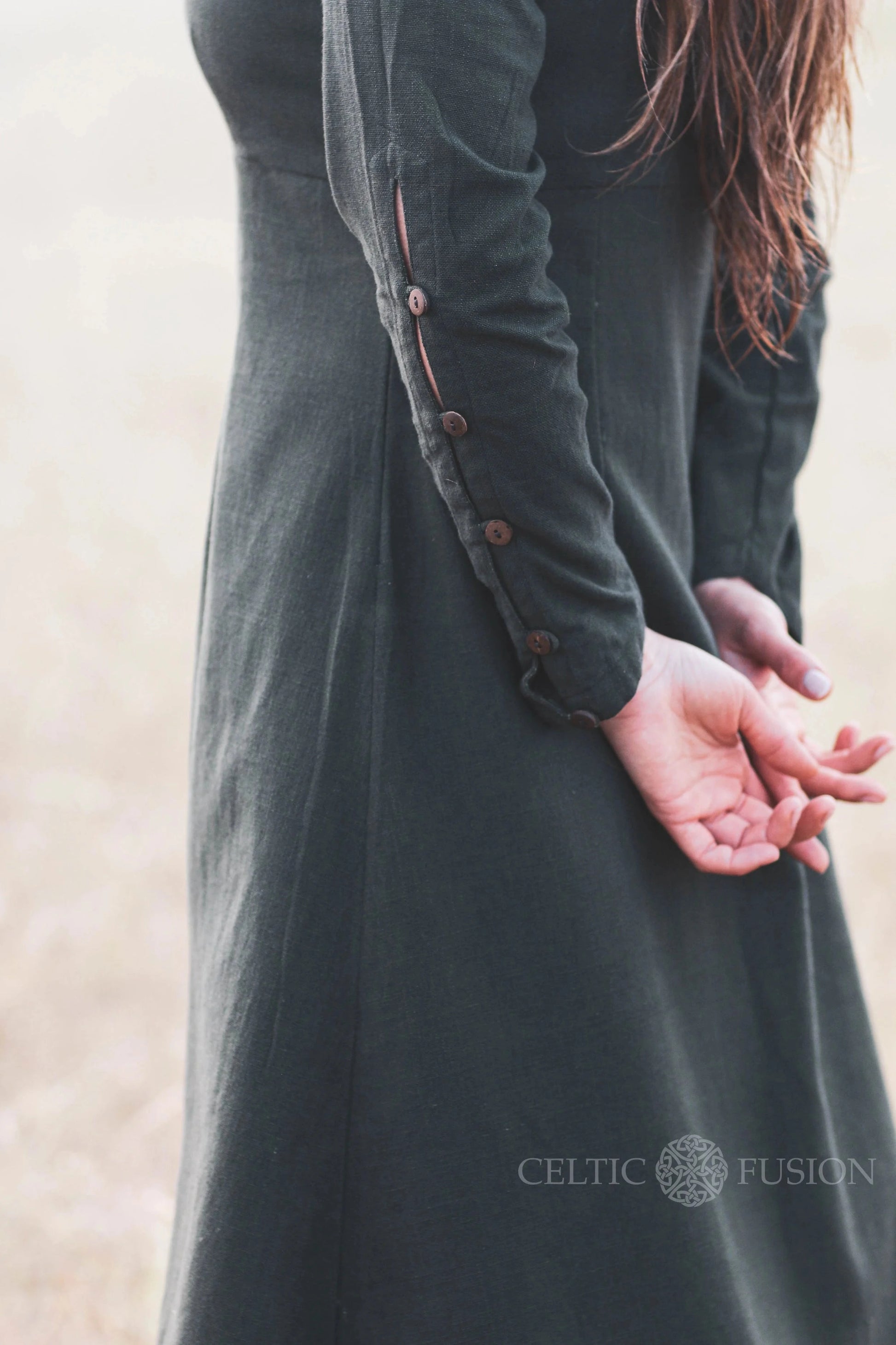 Detail of sleeve buttons on a green Celtic dress, showing the craftsmanship of this breathable long sleeve folklore dress.
