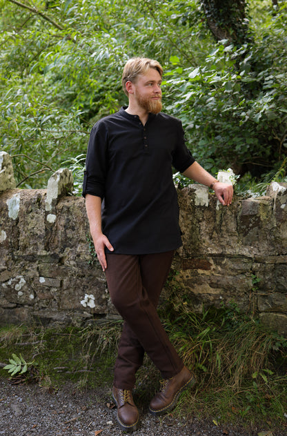 Dubh Celtic Embroidered Shirt styled with dark trousers, featuring a modern collarless cut and quater button detail