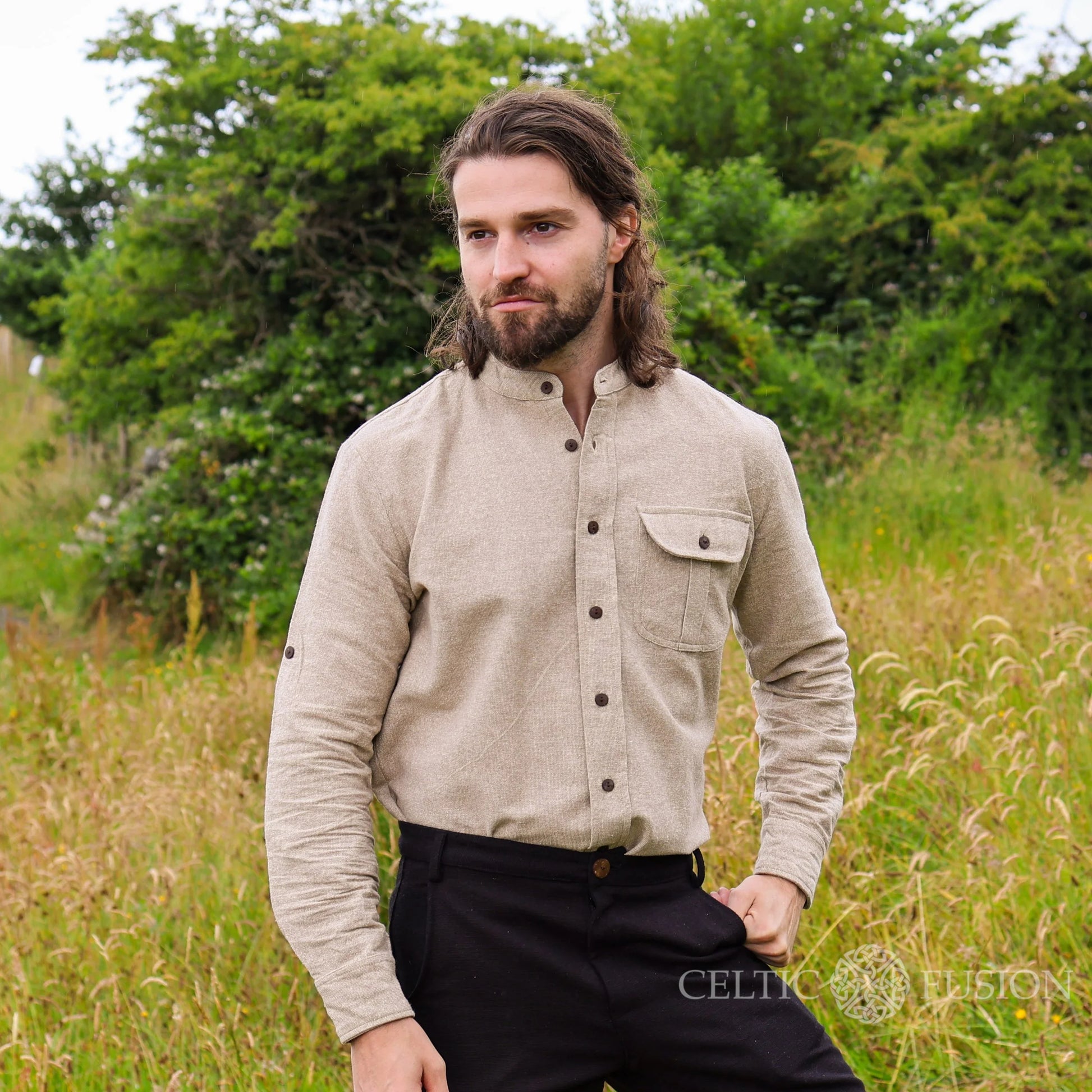 Men’s alternative wedding shirt in earthy beige cotton slub with collarless neckline, rolled sleeves and Celtic shield embroidery