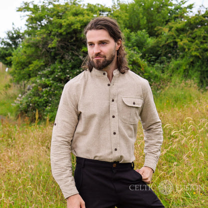 Men’s alternative wedding shirt in earthy beige cotton slub with collarless neckline, rolled sleeves and Celtic shield embroidery