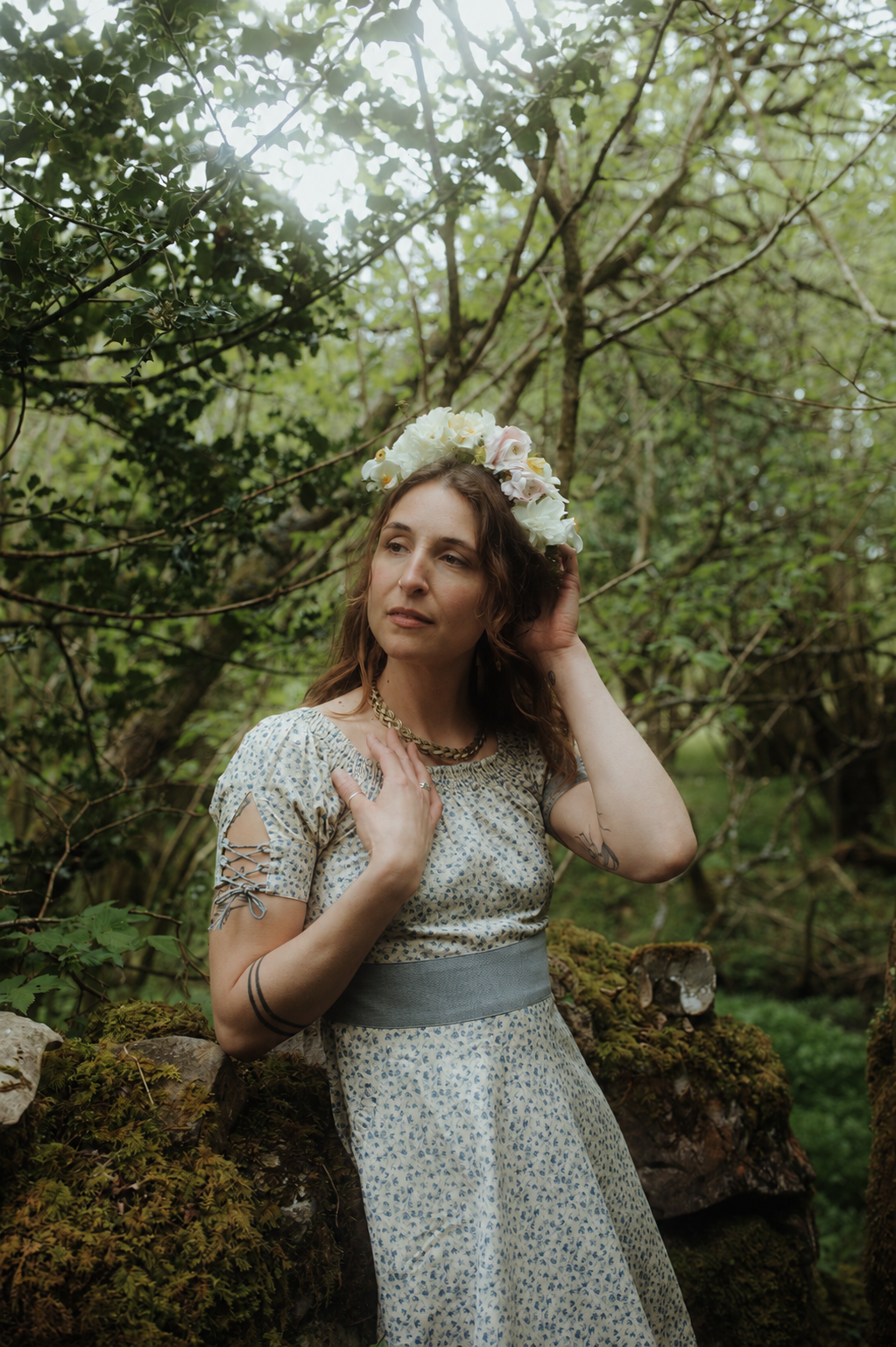Garden party wedding guest dress in blue floral linen blend fabric, styled with a flower crown in an Irish woodland setting.