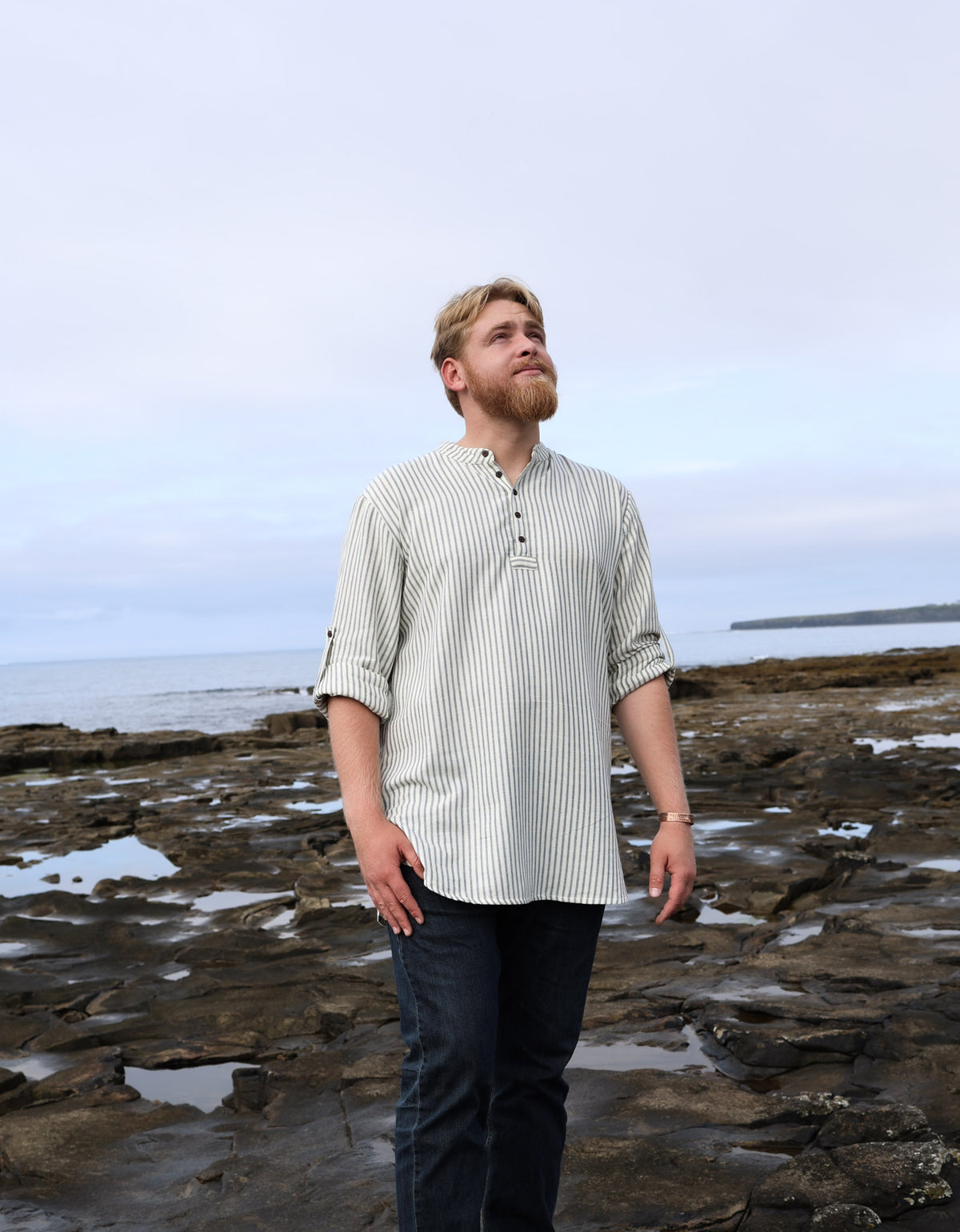 Men’s cream and blue cotton striped grandfather shirt with collarless neckline, long sleeves and relaxed fisherman-style fit.