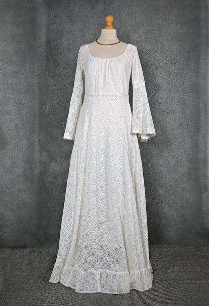 Off-white cotton lace bridal gown on mannequin with soft square neckline, long lace sleeves, and gently flared full skirt