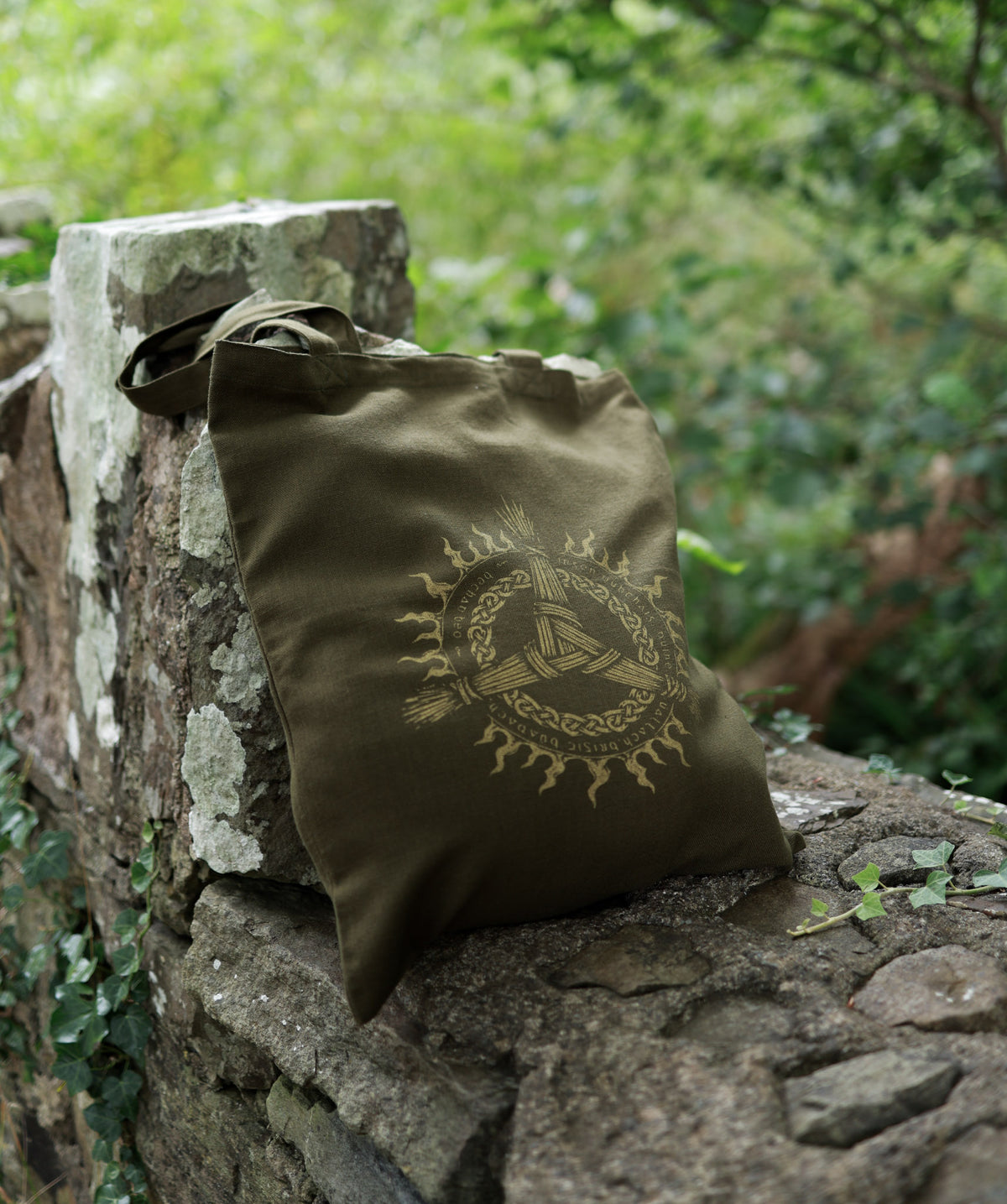 Olive green Brigid folklore tote bag with Celtic-inspired printed artwork and Irish verse detailing.