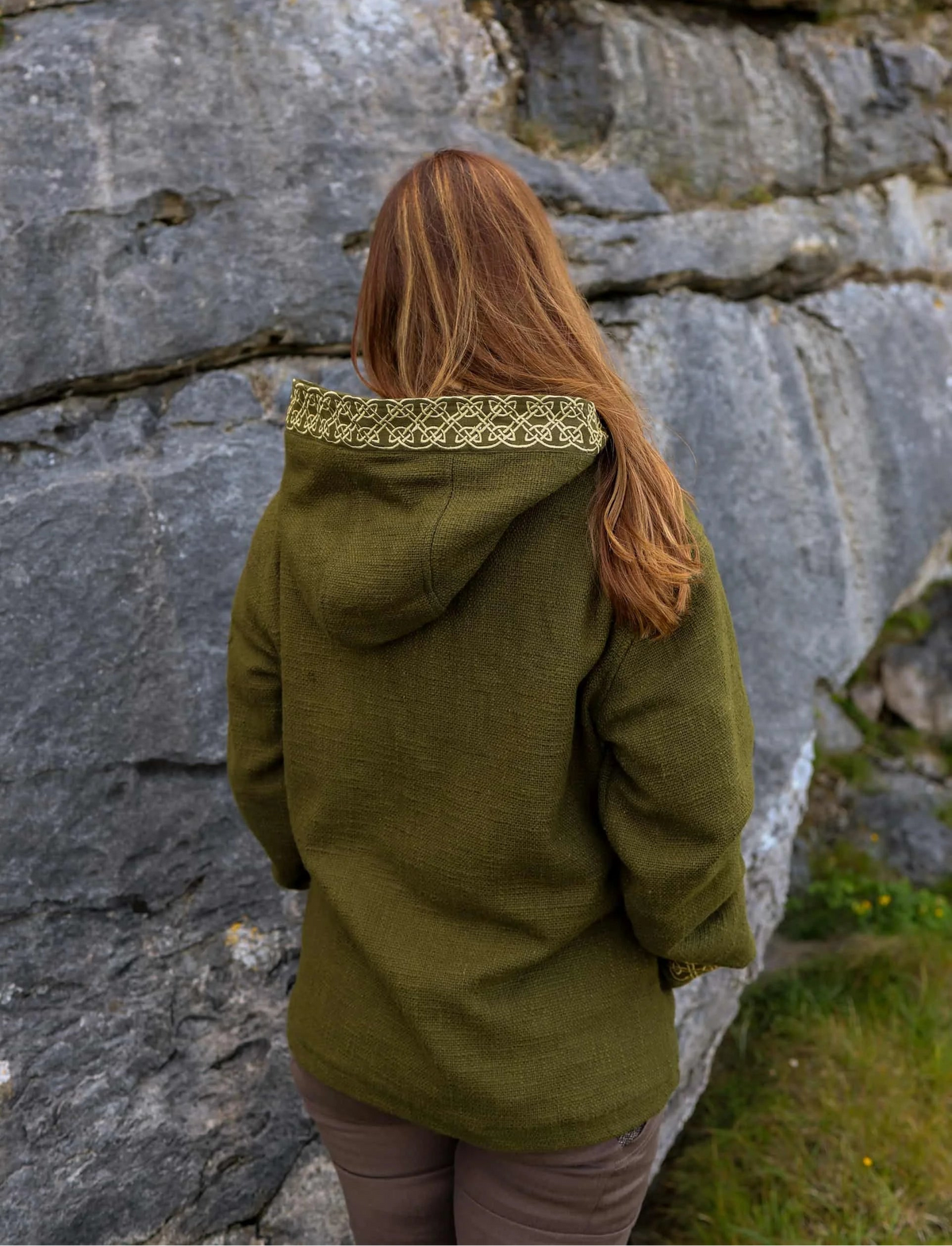 Back view of olive green Celtic hooded jacket showing handwoven cotton texture and embroidered knotwork hood trim.