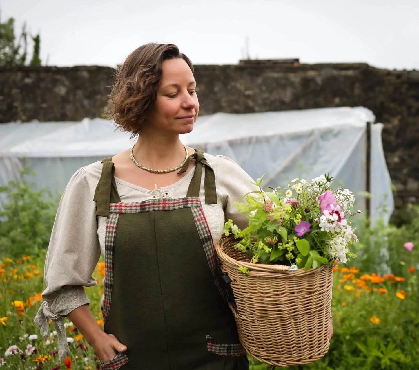 Relaxed cottagecore Green overalls with tweed check details worn in a flower garden with a flower basket