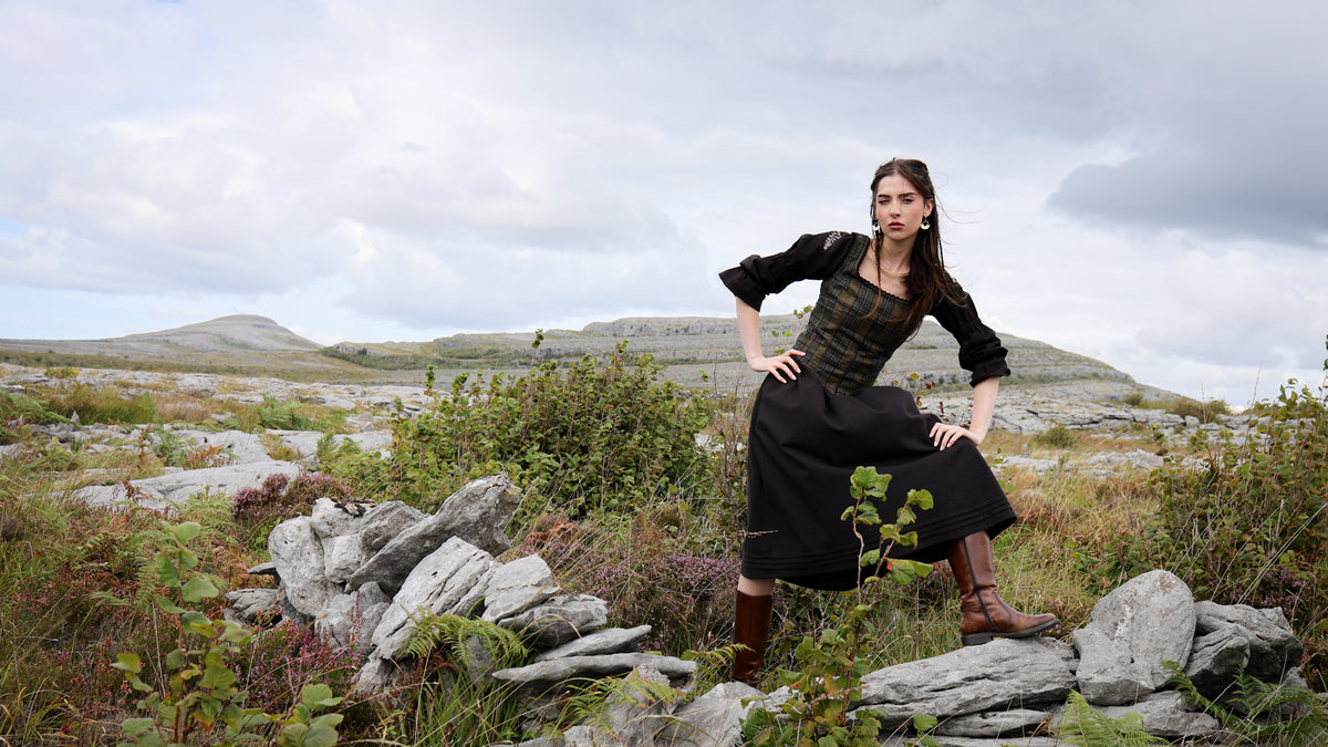 Woman in tweed bodice and Folk style dress Surrounded by irish landscape 