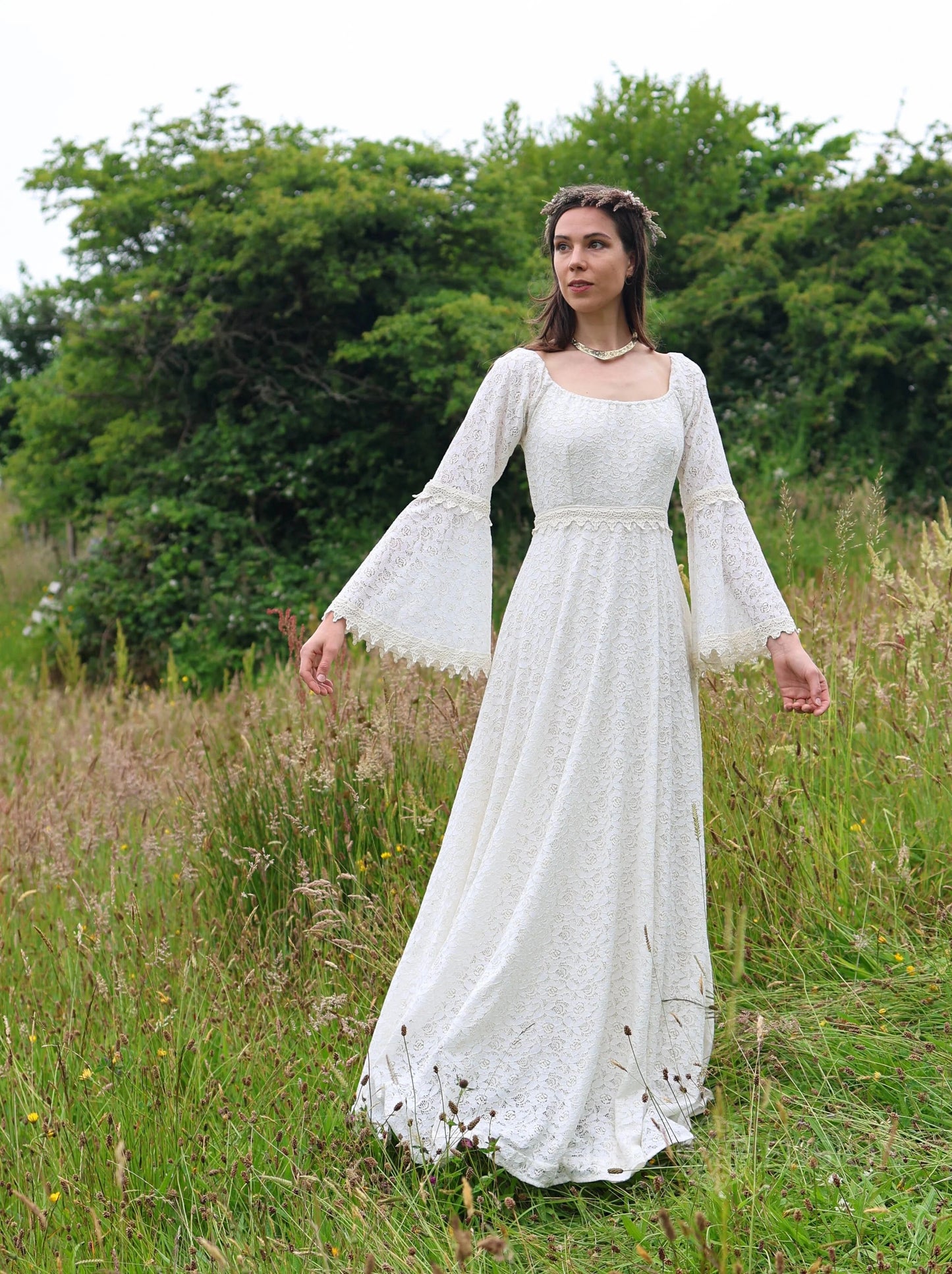 Bébhinn Boho Lace Wedding Dress outdoors, sustainable cotton lace gown with bell sleeves and full-length boho bridal silhouette.