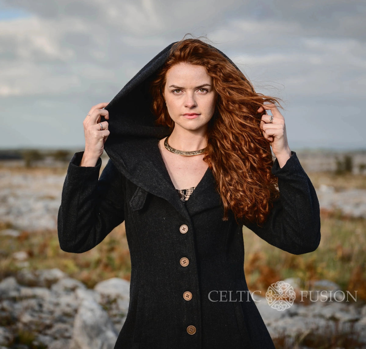 Close-up of black Princess wool coat with oversized hood, fitted bodice and statement button front created by Celtic Fusion folklore designs