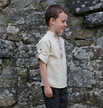 Side view of boys Viking style cotton shirt with roll-up button sleeves, lace-up neck and embroidered Vegvisir symbol