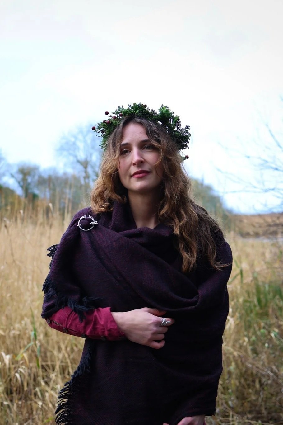 Celtic shawl in maroon and black with silver Trinity brooch styled as an elegant layered wrap