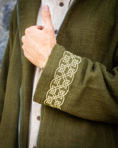 Close-up of a green cotton jacket with Celtic knot embroidery on the sleeve.