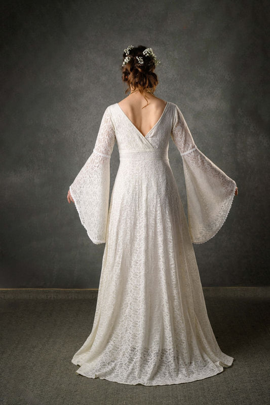 Back view of ivory cotton wedding dress with low V back, fitted waist and long bell sleeves