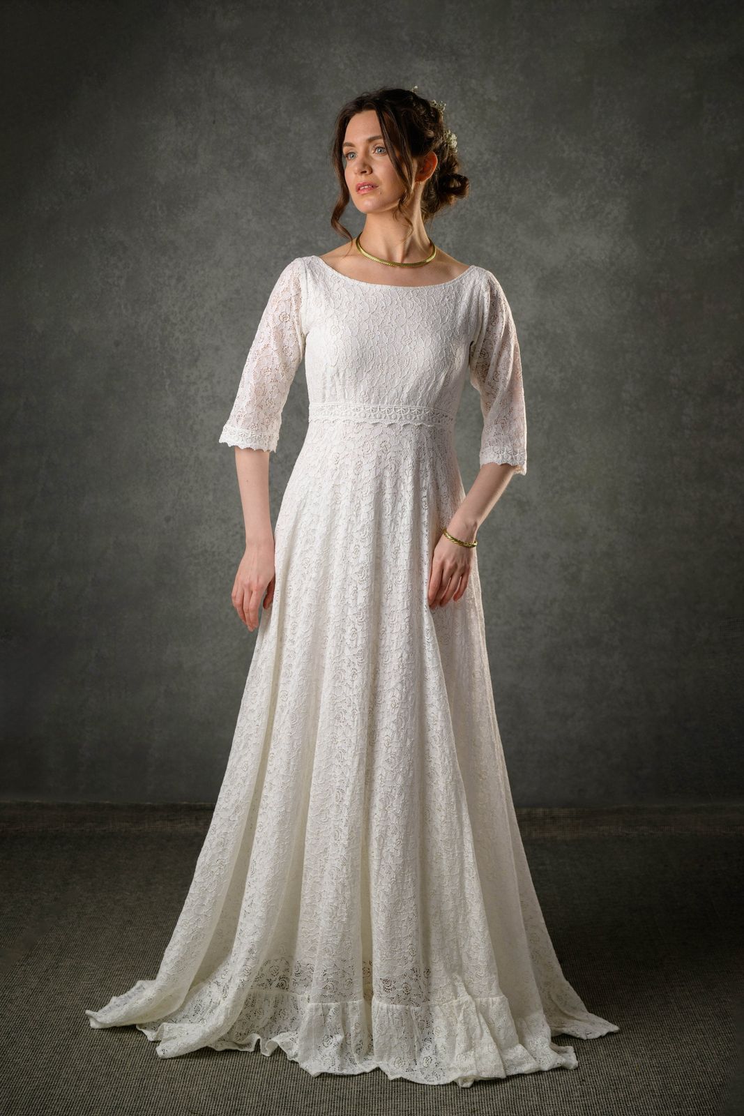Ivory lace bridal gown with bateau neckline, three quarter sleeves and flowing full-length skirt