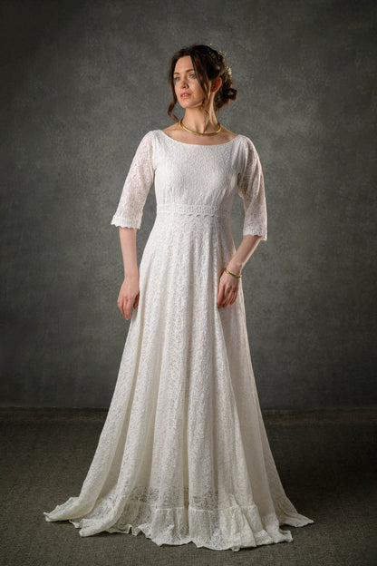 Ivory lace bridal gown with bateau neckline, three quarter sleeves and flowing full-length skirt