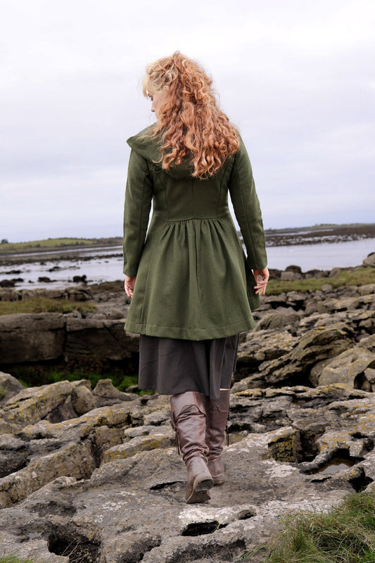Back view of a dark green hooded coat for women with a softly fitted waist and flared midi skirt shape.