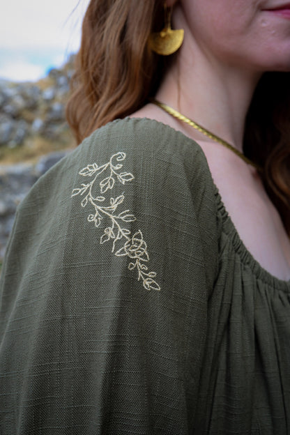 Close-up of delicate botanical embroidery on the shoulder of the Fiadh sage green folklore dress