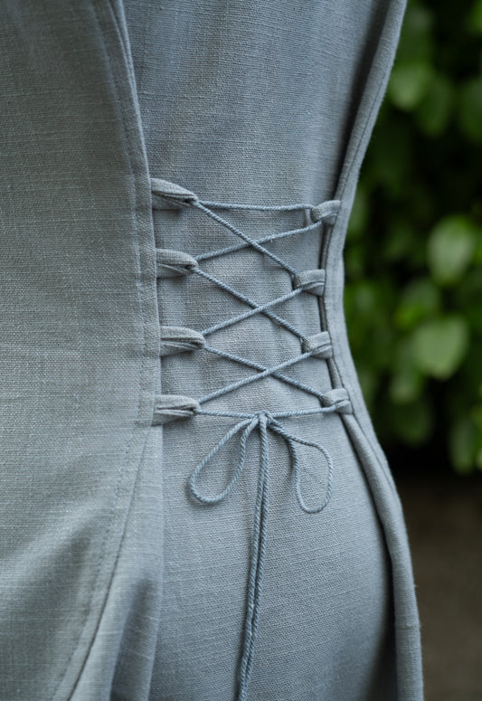 Natural cotton hooded folklore dress showing the adjustable corset lace-up back.