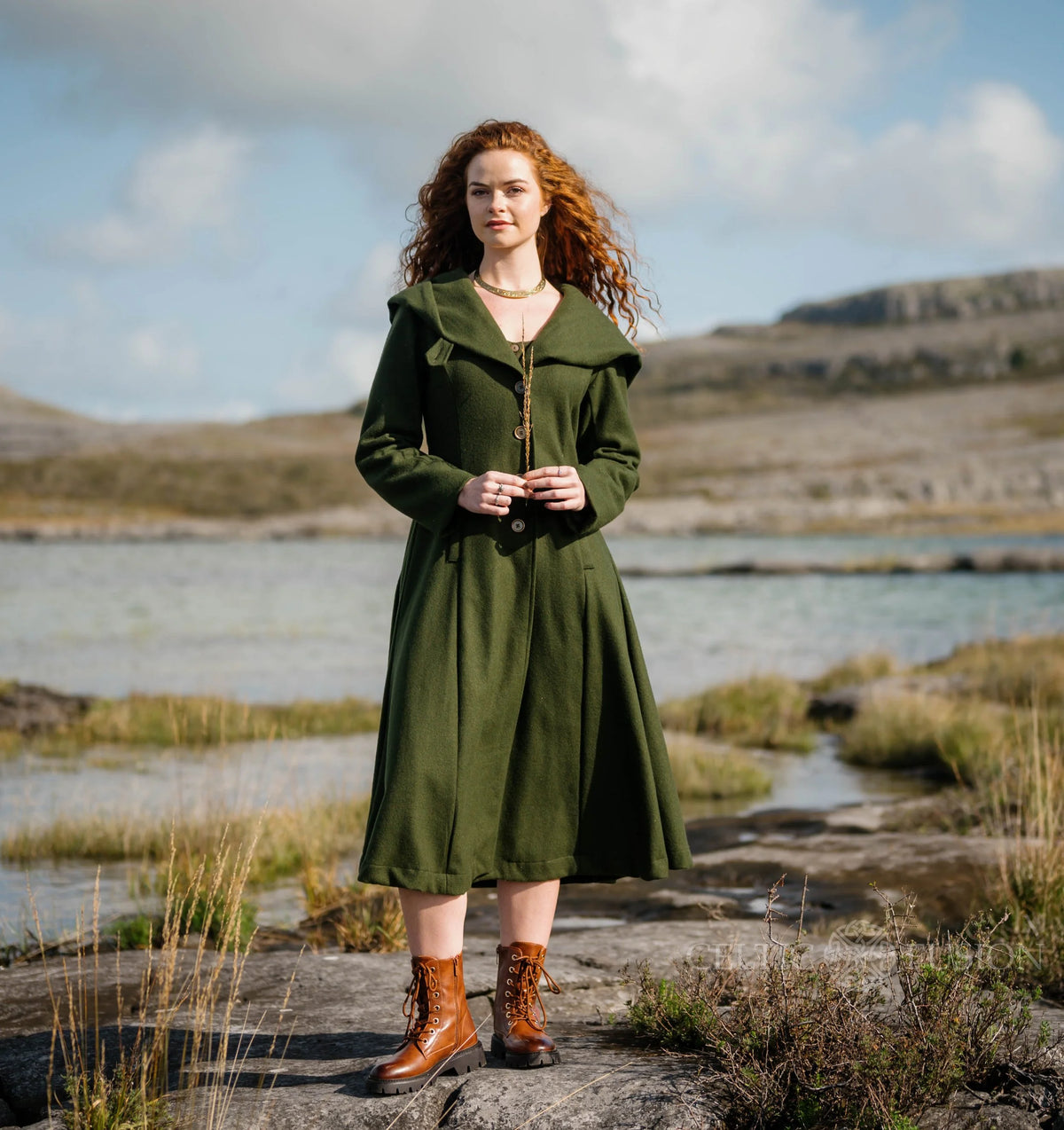 Woman wearing forest green Princess wool coat with tailored bodice, full skirt and romantic folklore styling outdoors