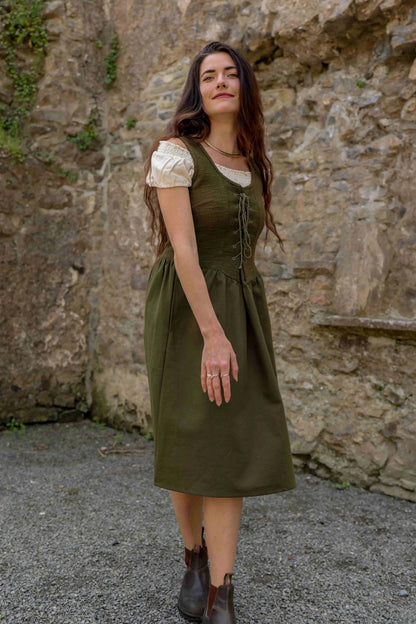Green Corset Dress shown from the side as a layering dress, with a soft cream bunched sleeve blouse underneath