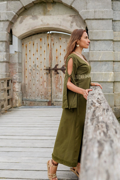Profile view of Maeve Celtic Dress, green handfasting dress with bell sleeves, Celtic knot embroidered waist and full length skirt.