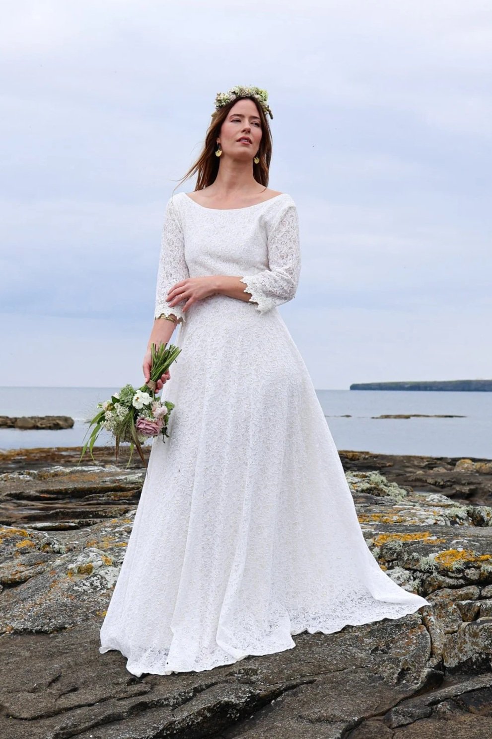 Folklore-inspired ivory bridal dress with cotton lace overlay, fitted bodice and flowing hemline