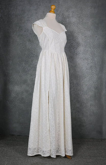 Ivory floral cotton lace wedding dress on mannequin with corset bodice, gathered shoulder straps and front slit