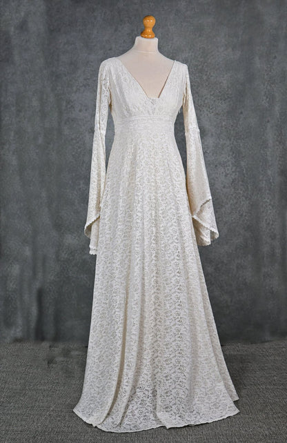 Ivory cotton lace bridal dress with plunging neckline, long bell sleeves and full-length skirt on mannequin renaissance gown styling