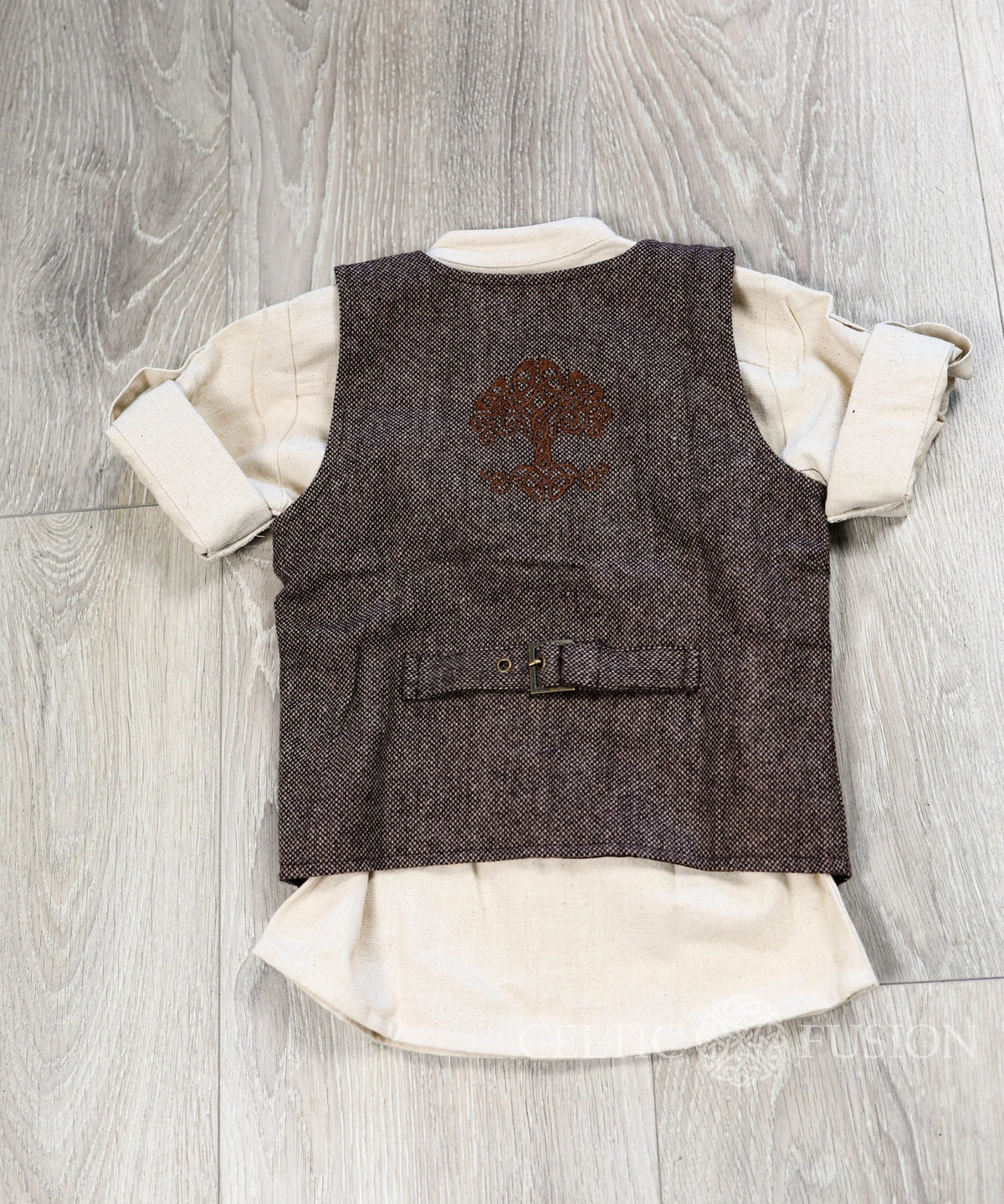 Back flat lay of kids Celtic tweed waistcoat showing embroidered Tree of Life and adjustable buckle strap