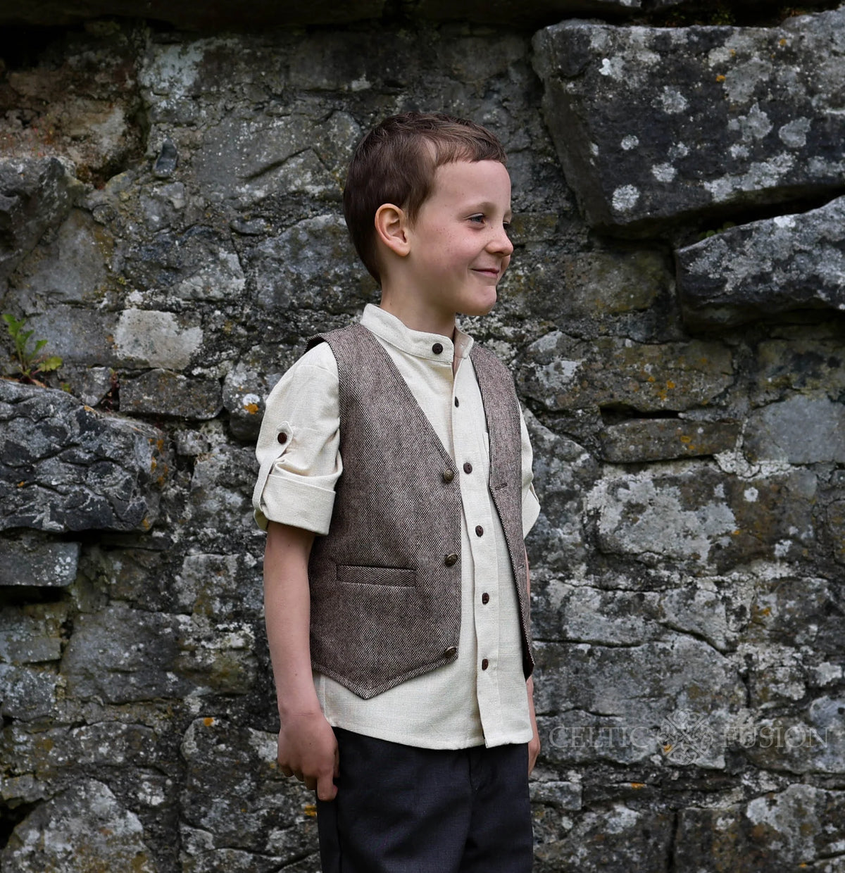 Side view of kids brown tweed waistcoat showing fitted shape, front pockets and heritage styling