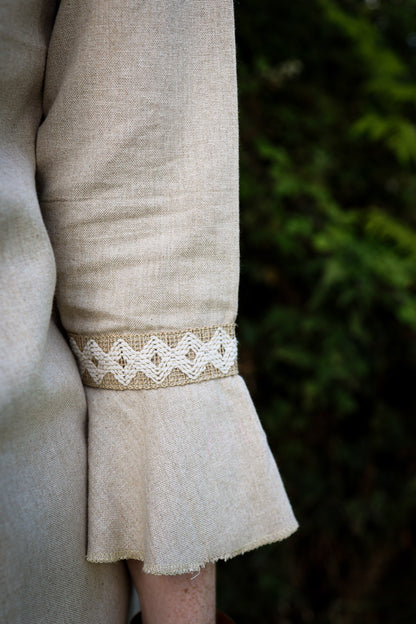 Close-up of natural linen bell sleeve with handwoven jute trim and softly flared frill cuff.