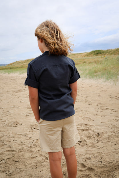 Back view of navy boys medieval shirt showing relaxed fit and roll-up sleeves